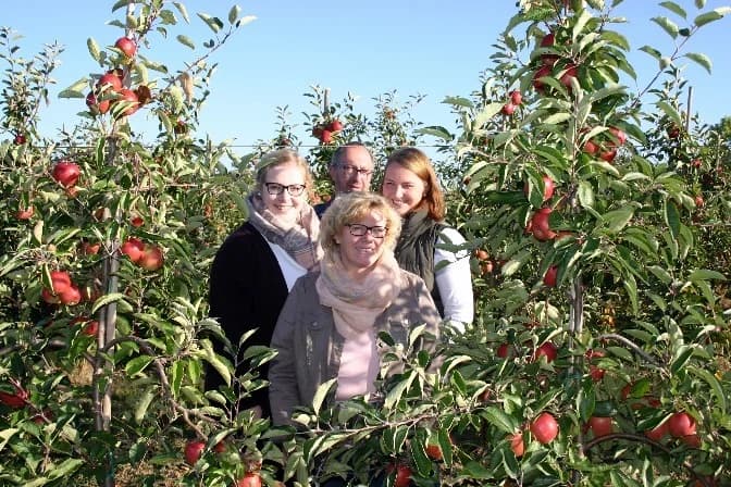 Familie Heinrichs zwischen den Apfelbäumen des Biohofs Voreifel